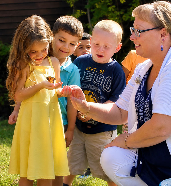 Child studying batterfly with Elli